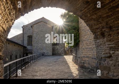 Zufluchtsort La Verna an einem sonnigen Tag, der durch den Bogen des Tunnels gesehen wird Stockfoto