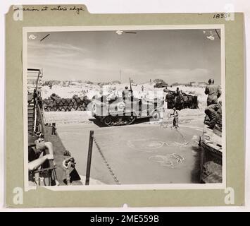 Während der Invasion von Sizilien werden US-Küstenwache beim Abladen von Vorräten am Strand beobachtet. Diese Vorräte, die von einem Transport der Küstenwache vor der Küste geliefert wurden, waren für die Unterstützung der Infanterie während der kritischen frühen Phasen der Invasion von entscheidender Bedeutung. Stockfoto