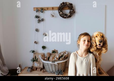 Lächelndes Mädchen mit Cockerspaniel-Hund zu Hause Stockfoto