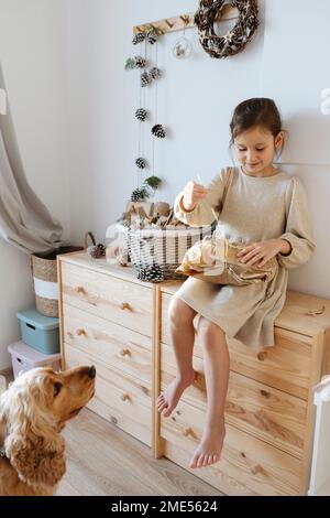 Lächelndes Mädchen, das zu Hause im Schrank sitzt Stockfoto