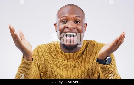 Was soll ich sagen? Studio-Porträt eines attraktiven jungen Mannes, der überrascht aussieht vor grauem Hintergrund. Stockfoto