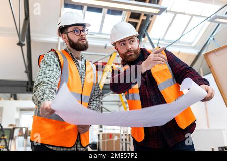 Ingenieur Gesten und Gespräch mit Kollegen auf der Baustelle Stockfoto