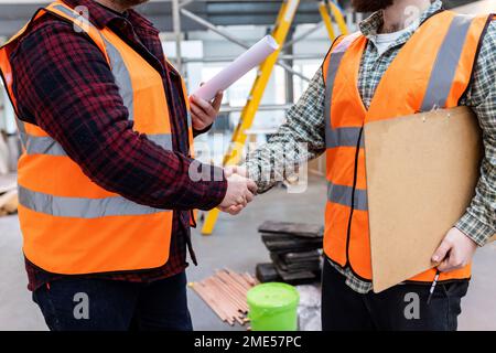 Ingenieure schütteln sich auf der Baustelle die Hände Stockfoto