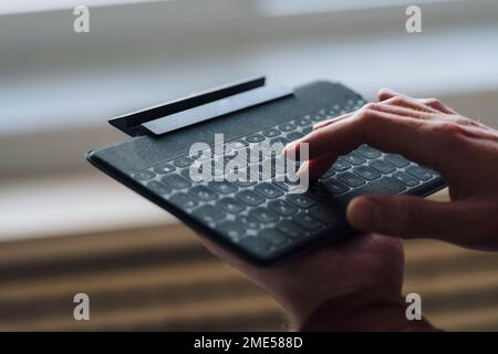 Hände eines Geschäftsmannes, der eine drahtlose Tastatur verwendet Stockfoto
