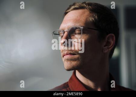 Geschäftsmann mit geschlossenen Augen im Büro Stockfoto