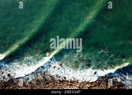 Ein Luftblick auf die Wellen des Meeres, das vom Strand abgespült wird Stockfoto