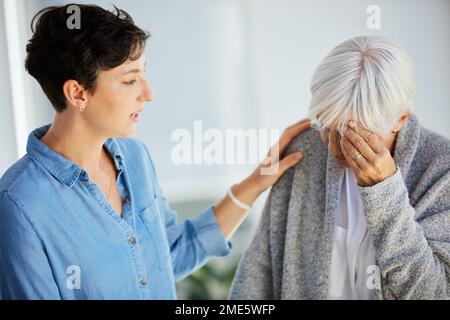 Ich bin immer für dich da. Eine liebevolle junge Frau, die ihre verärgerte alte Mutter zu Hause tröstet. Stockfoto