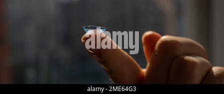 Nahaufnahme einer Kontaktlinse am Zeigefinger einer Frau. Stockfoto