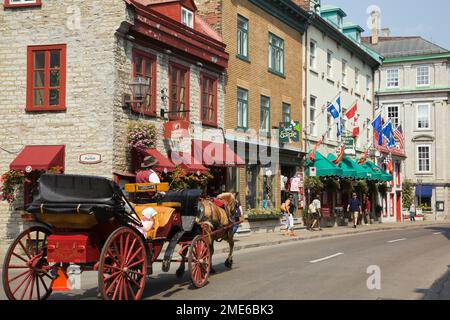 Touristen, die im Sommer in einer Pferdekutsche entlang der Rue Saint-Louis in der Oberstadt der Altstadt von Quebec City reiten, Quebec, Kanada. Stockfoto