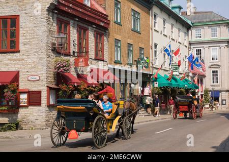 Touristen, die im Sommer in einer Pferdekutsche entlang der Rue Saint-Louis in der Oberstadt der Altstadt von Quebec City reiten, Quebec, Kanada. Stockfoto