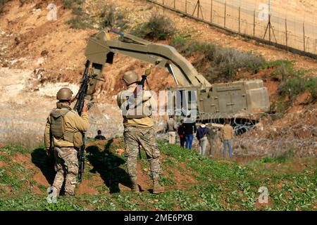 Beirut. 23. Januar 2023. Libanesische Soldaten beobachten am 23. Januar 2023 einen israelischen Bagger, der Verteidigungsbefestigungen in der Nähe der libanesisch-israelischen Grenzen errichtet. Die Interimstruppe der Vereinten Nationen in Libanon (UNIFIL) hat am 20. Januar davor gewarnt, Arbeiten oder Aktivitäten durchzuführen, die in der Nähe der libanesisch-israelischen Grenzen zu Spannungen führen könnten, so die Nationale Nachrichtenagentur. Ein Bagger von israelischer Seite hat kürzlich die Grenzlinie zwischen den beiden Ländern überschritten und die libanesische Armee veranlasst, die israelische Militäroperation einzustellen. Kredit: Ali Hashisho/Xinhua/Alamy Live News Stockfoto