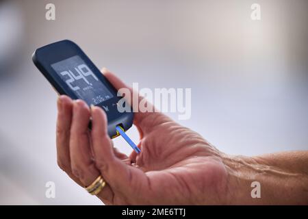 Hände, Diabetes und Glukometer, Werkzeug oder Messung für Blutzuckerspiegel, Einheiten oder Gesundheitswesen. Handgehaltenes Messgerät für medizinische Diagnosegeräte zum Messen Stockfoto