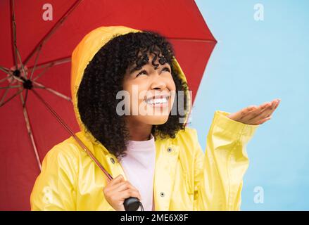 Schwarze Frau, Regenschirm oder Hand, die auf isoliertem blauem Hintergrund in Brasilien Regen fängt. Person, Student oder auf Wettervorhersage hin kommt Wasser Stockfoto