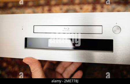Paris, Frankreich - 18. Okt. 2023: POV männliche Hand hält neues Onkyo BD-SP809 Blu-ray Deck der Spitzenklasse mit großem Digitaldisplay Stockfoto
