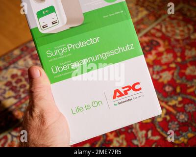 Frankfurt, Deutschland - 2. Dezember 2022: POV männlicher Kunde hält APC American Power Conversion Corporation von Schneider Electric Kartonpaket mit Life steht auf dem Slogan Stockfoto