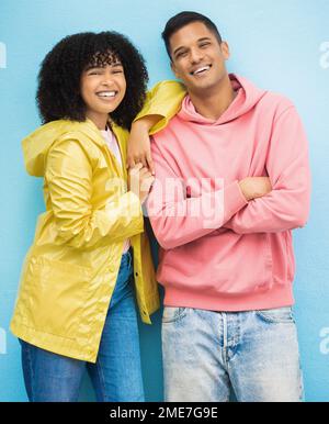 Ein paar Freunde, Porträt oder Verbundenheit auf isoliertem blauem Hintergrund in Mode-, Trend- oder coolen Kleidungsstücken. Lächeln, glücklicher Mann oder schwarze Frau mit Afro Stockfoto