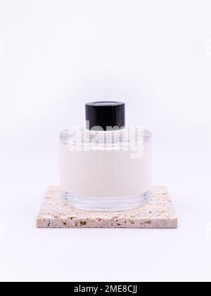 Das Holzaroma bleibt in einem Glaskolben haften, der mit flüssiger Geschmackssubstanz gefüllt ist, isoliert auf weißem Hintergrund, Seitenansicht Stockfoto