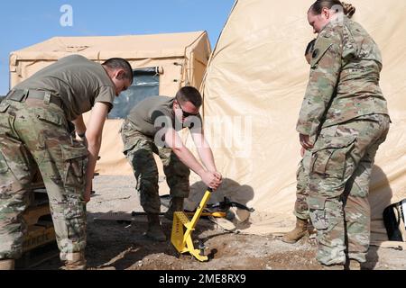 USA Army PFC. LEJS Kravic, Left, SPC. Joshua Feeheley, Middle und Sgt. Jacqulne Blackiston von der Combat Aviation Brigade 29., Maryland Army National Guard arbeiten zusammen, um am 14. August 2022 in Camp Grayling, Michigan, einen Zelpfahl vom Boden zu entfernen. Das 29. CAB, angeführt von Oberst Richard Ferguson, verfügt über etwa 100 Soldaten der Nationalgarde der Maryland Army, die während des nördlichen Streiks 22 vom 6. Bis 20. August 2022 Befehls- und Kontrollkapazitäten für alle Bereiche bereitstellten. Stockfoto