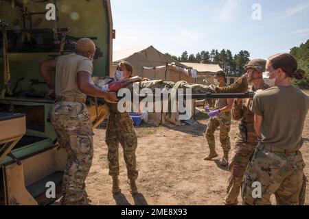 USA Armeesoldaten des 146. Multifunktionalen medizinischen Bataillons, 1171. Medical Company Area Support entladen rollspielende Patienten von einem Humvee 2-CT Krankenwagen während einer Massenverletzten-Simulation bei der Übung Northern Strike 22-2 in Grayling, Michigan, 13. August 2022. Northern Strike wurde entwickelt, um etwa 7.400 Mitglieder des Dienstes mit verschiedenen Schulungsformen herauszufordern, die ihre Fähigkeit testen, schnell zu implementieren und rechtzeitige Unterstützung in einem entscheidenden Aktionsumfeld zu leisten. Stockfoto