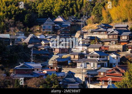 Japanische Häuser in einem kleinen Bergdorf zwischen Bäumen an sonnigen Tagen Stockfoto