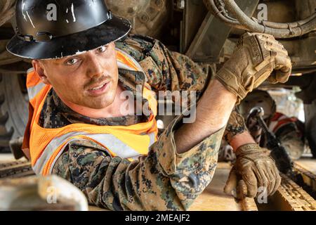 USA Marine Corps Lance CPL. Griffin Cummins, ein Einschiffungsspezialist beim 2. Landing Support Battalion (LSB), Combat Logistics Regiment 27, 2. Marine Logistics Group, kriecht unter einem Abriss für Logistiksysteme (LVSR) in einem Eisenbahnwaggon in Morehead City, North Carolina, 15. August 2022. 2. LSB und 2. Transportation Battalion führten von August 15 bis August 22 Eisenbahnoperationen durch, um Ausrüstung und Fahrzeuge für den bevorstehenden Kurs 1-23 für Waffen- und Taktiklehrer (WTI) in Yuma, Arizona, zu liefern. Stockfoto