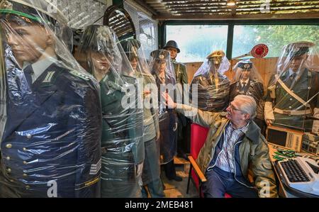 Eggersdorf, Deutschland. 19. Januar 2023. Christian Paul, Sammler, sitzt in seinem kleinen privaten Museum unter verschiedenen Figuren mit Uniformen, die in Plastiktüchern verpackt sind. Mit einer Polizei begann Lada vor etwa 15 Jahren, was sich jetzt zu einer umfangreichen Sammlung von Blaulicht entwickelt hat. Viele Uniformen und noch mehr alte Technologie, es gibt den Sammler Christian Paul zu bewundern. (Zu dpa-KORR „Täuschungsgeist – wenn Oldtimer der DDR renoviert werden“) Kredit: Patrick Pleul/dpa/Alamy Live News Stockfoto