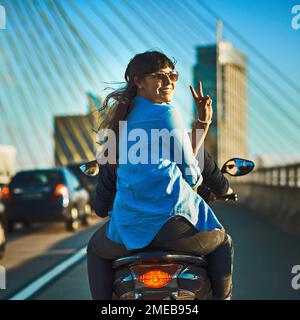 Auf ein Abenteuer. Ein junges, attraktives Paar, das mit dem Roller durch die Stadt fährt. Stockfoto