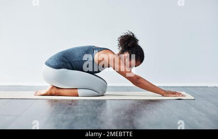 Ich mache Yoga, weil es mir nützt. Eine sportliche junge Frau, die Yoga praktiziert. Stockfoto