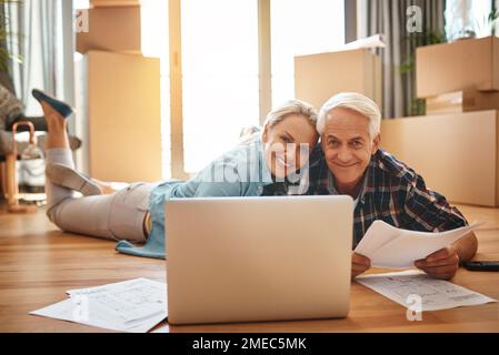 Das Beste an einem neuen Haus, es zu dekorieren. Porträt eines erwachsenen Ehepaars, das einen Laptop benutzt und am Umzugstag gemeinsam Papierkram durchsucht. Stockfoto