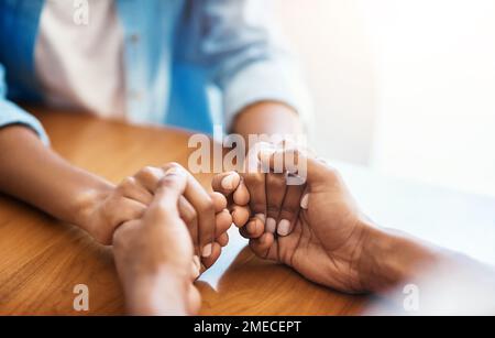 Gemeinsam können wir alles überwinden, was uns in den Weg gestellt wurde. Nahaufnahme von zwei unbekannten Personen, die sich zu Hause wohlfühlen. Stockfoto