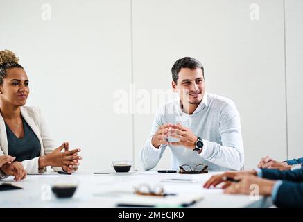 Große Dinge passieren immer, wenn sie ihre Fachkenntnisse kombinieren. Eine Gruppe von Geschäftsleuten, die ein Meeting in einem Büro abhalten. Stockfoto