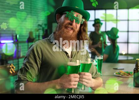 Komischer bärtiger Mann mit Gläsern Bier, der St. Patrick's Day im Pub Stockfoto