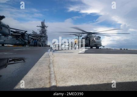 220817-N-XN177-2354 PHILIPPINE SEA (17. August 2022) – Ein CH-53 Super-Hallion-Hubschrauber, MV-22 Osprey-Tiltrotor-Flugzeug, das der Marine Medium Tiltrotor Squadron (VMM) 262 (verstärkt) zugewiesen ist, Und ein MH-60s Sea Hawk Hubschrauber, der der Helicopter Sea Combat Squadron (HSC) 23 zugeteilt wurde, bereitet sich auf den Start vom amphibischen Angriffsträger USS Tripoli (LHA 7) vor, 17. August 2022. Tripolis ist im US-amerikanischen 7.-Flottengebiet tätig, um die Interoperabilität mit Verbündeten und Partnern zu verbessern und als einsatzbereite Eingreiftruppe zur Verteidigung des Friedens und zur Aufrechterhaltung der Stabilität in der Region Indo-Pazifik zu dienen. Stockfoto