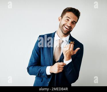 Rate mal, wer heute heiratet. Studioaufnahme eines gutaussehenden jungen Bräutigams vor grauem Hintergrund. Stockfoto