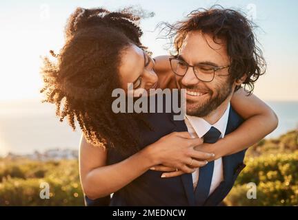 Hochzeit, gemischtrassige und Paare umarmen sich in der Natur, glücklich und aufgeregt, während sie Liebe, Anfang und Romantik feiern. Romantisch, verheiratet und glücklich, schwarz Stockfoto