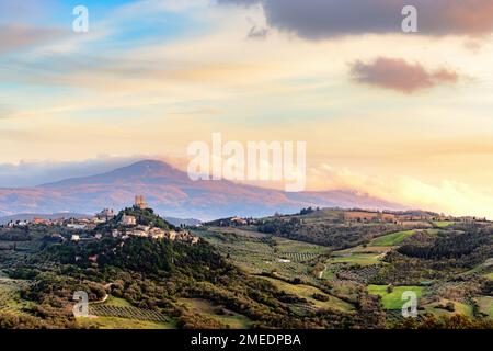 Blick über Castiglione d'Orcia im Abendlicht im Val d'Orcia in der Toskana, Italien, mit Monte Amiata im Hintergrund. Stockfoto