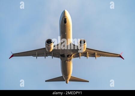 Passagierflugzeug fliegt im Himmel, Blick von unten. Flugzeugreisekonzept. Stockfoto