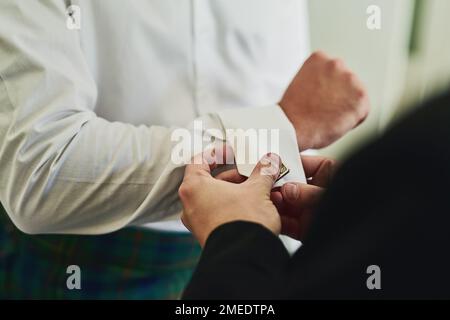 So sollte es gefaltet werden. Ein Mann, der sich nicht wiedererkennt, legt einen anderen mann in den Ärmel, um sich auf die Hochzeit vorzubereiten. Stockfoto