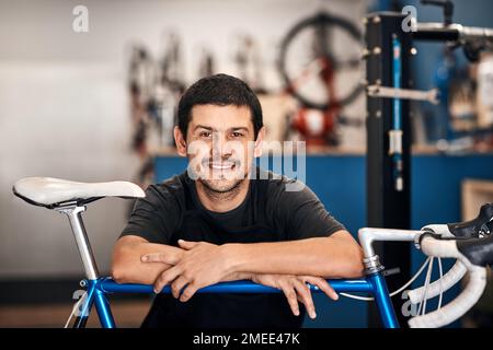 Der beste Fahrradreparaturmann der Stadt. Ein Mann, der in einer Fahrradwerkstatt arbeitet. Stockfoto