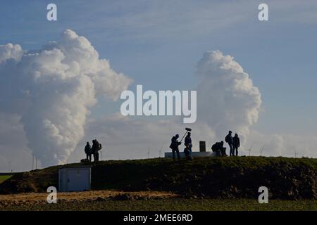Journalisten standen während der Proteste gegen den Klimawandel im Januar 2022 auf dem Fundament einer abgerissenen Windturbine im offenen Kohlebergwerk Garzweiler II Stockfoto