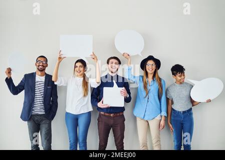 Man muss seine eigene Meinung im Geschäft haben. Eine vielfältige Gruppe von kreativen Mitarbeitern hält Sprechblasen in sich. Stockfoto