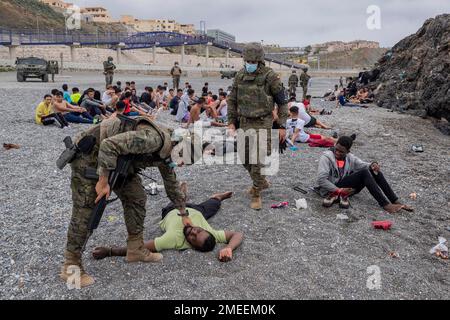 A Migrant Is Assisted By Soldiers Of The Spanish Army Near The Border A Migrant Is Assisted By Soldiers Of The Spanish Army Near The Border