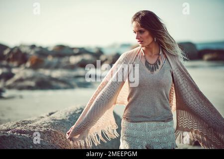 Sei so frei wie ich und komm ans Meer. Eine attraktive junge Frau, die einen Tag am Strand verbringt. Stockfoto