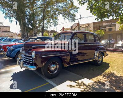 Lanus, Argentinien - 24. September 2022: Alte, rotes, burgunderrot 1940er Ford Super Deluxe-Limousine mit vier Türen in einem Park. 2022 AAA Oldtimer-Show. Seitenansicht. Stockfoto