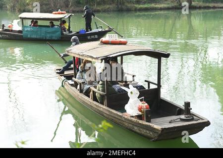 Hangzhou, Chinas Provinz Zhejiang. 24. Januar 2023. Touristen nehmen ein Boot mit einer hasenförmigen Laterne und besuchen den Xixi National Wetland Park in Hangzhou, der Hauptstadt der ostchinesischen Provinz Zhejiang, am 24. Januar 2023. Zur Feier des chinesischen Mondneujahrs fanden hier verschiedene Aktivitäten statt. Kredit: Weng Xinyang/Xinhua/Alamy Live News Stockfoto