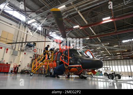 Am 17. August 2022 führt eine Luftwaffe der Küstenwache Kodiak die Wartung eines MH-65 Dolphin Hubschraubers in Kodiak, Alaska, durch. Die Besatzungsmitglieder bemühen sich, die Hubschrauber der Flugstation auf dem höchstmöglichen Stand der Einsatzbereitschaft zu halten. USA Foto der Küstenwache von Petty Officer 3. Klasse Ian Gray. Stockfoto