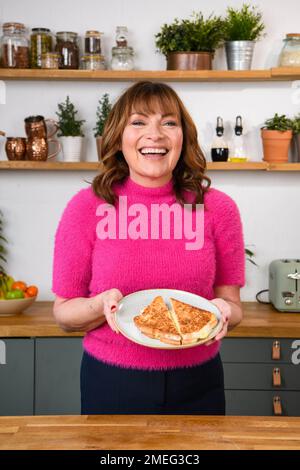 REDAKTION NUR TV-Moderatorin und Botschafterin der Gewichtler, Lorraine Kelly, wird gezeigt, wie man das landesweit beliebteste „January Blues“-Komfortessen zubereitet, einschließlich einer Käsetoastie, von Koch Zena Kamgaing, um hervorzuheben, dass man mit WW immer noch Gewicht verlieren kann, ohne dabei zu verlieren. Ausgabedatum: Dienstag, 24. Januar 2023. Stockfoto