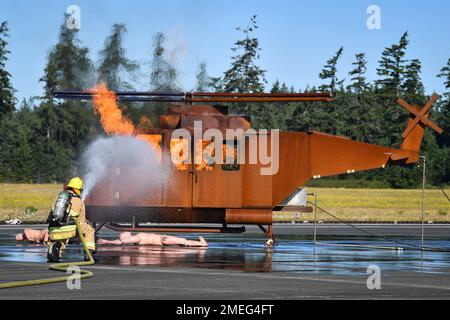 Aviation Boatswain's Mate- Aircraft Handling 2. Class Dakota Montoya löscht ein Feuer während einer Übung für Flugzeugunfälle auf dem Naval Outlying Field in Coupeville, Washington, 17. August 2022. Bei der gemeinsamen Schulung wurden die Verfahren zur Reaktion auf Flugzeugunfälle unserer Federal Fire, Search and Rescue und lokalen Ersthelfer getestet. Stockfoto