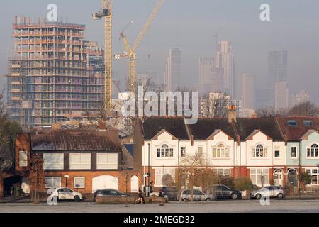 Die schlechte Luftqualität verdeckt zum Teil die hohen Hochhäuser in Nine Elms, die am 23. Januar 2023 in London, England, am Ruskin Park in Lambeth, Süd-London, grenzten. Im Vordergrund steht Higgs Yard, eine von Wohngebäuden betriebene Entwicklung für gemischte Anwendungen auf dem Higgs Industrial Estate in Loughborough Junction, London SE24. 134 neue Häuser und 4,150 m2 gewerbliche Bodenfläche. 50 % der Häuser werden erschwinglich sein. Stockfoto