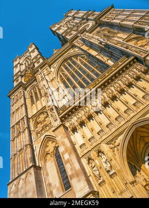 Blick auf die gotische Architektur der historischen Westminster Abbey mit zwei Türmen und komplizierten Details vor einem klaren blauen Himmel Stockfoto